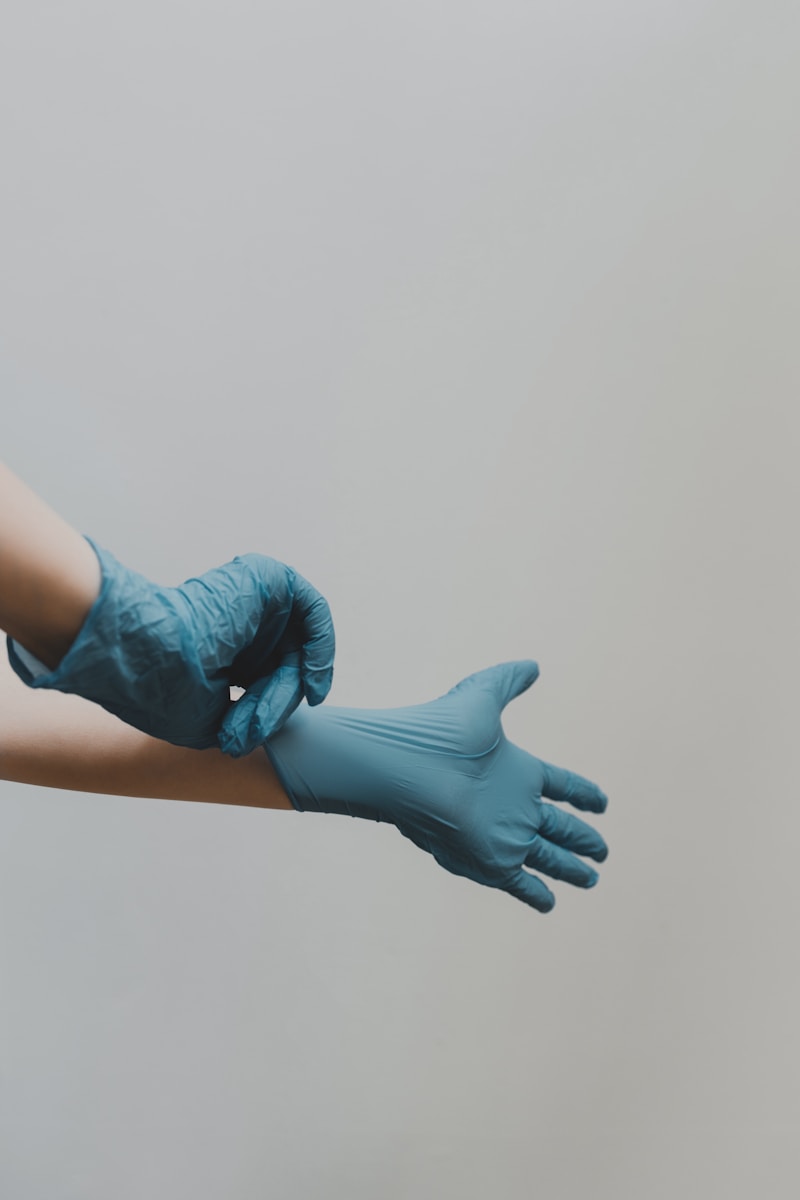 Photo by Clay Banks person in blue gloves and blue denim jeans